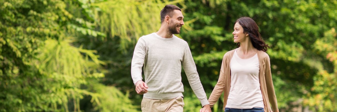  A couple walking hand in hand at a park during summer season enjoying life after rehab in 